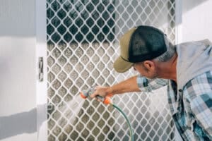 man cleaning screen door